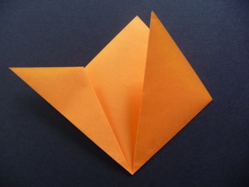 5. Take one of those points and fold it so the edge aligns with the side of the square.